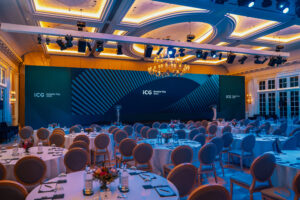 Custom-build corporate event stage with LED wall screens at a global conference.